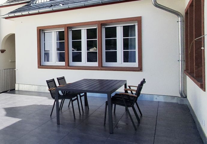 Terrasse mit Esstisch und Sonnenliegen