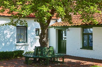 Eingang des Heimatmuseum Seemannshus mit Rundbank um einen Baum